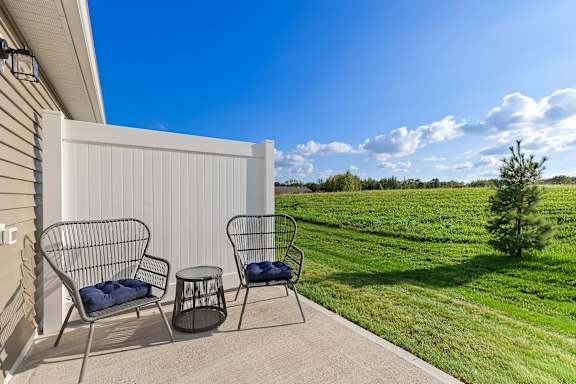 Two chairs and a table are on a patio.