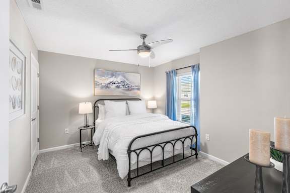 A bedroom with a large bed and a painting on the wall.