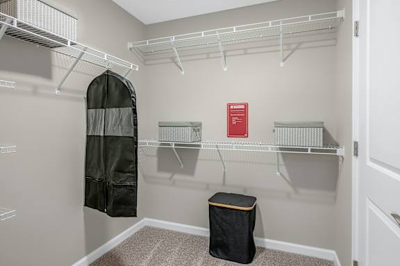 A small closet with a black bag on the floor.
