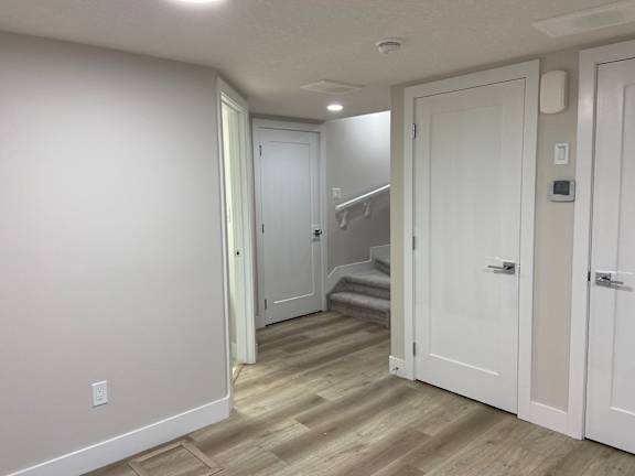 A hallway with a staircase and two doors.