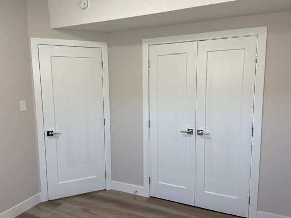 Three white doors in a room.