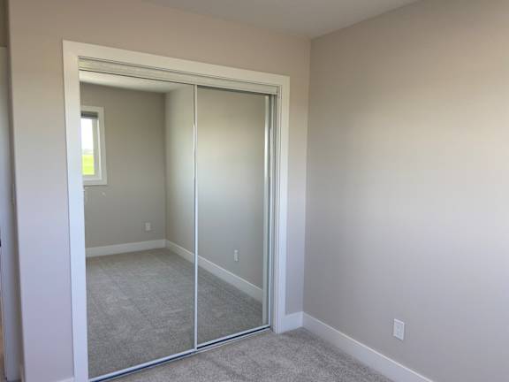 A room with a carpeted floor and a sliding glass door.