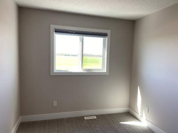 A room with a window and a carpet on the floor.