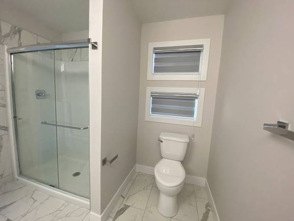 A white toilet in a bathroom with a glass shower door.
