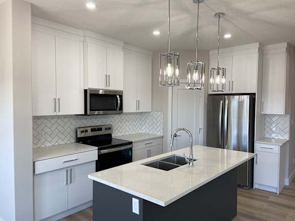 Floor Plan  A kitchen with white cabinets and a black island.