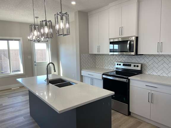 A kitchen with a white counter top and black appliances.