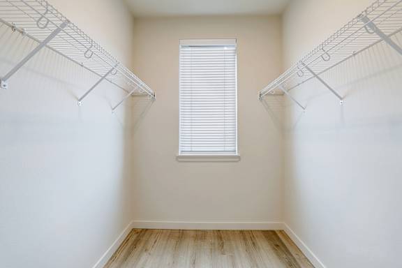 Empty room with a window and shelves on the wall.