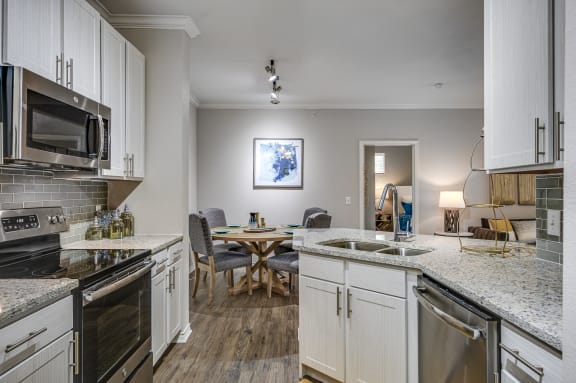 Kitchen With White Cabinetry And Appliances at Riachi at One21, Texas