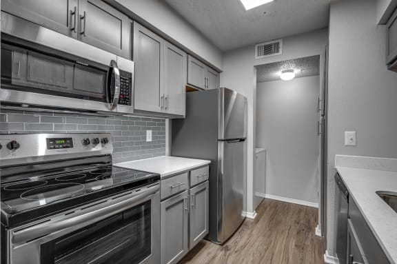 Kitchen with Stainless Steel Appliances at Wellington at Willow Bend Apartments, Plano, TX, 75093