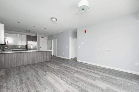 A spacious room with a grey floor and white walls.