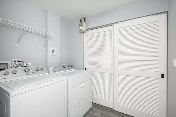 A white laundry room with a washer and dryer.