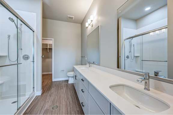 A modern bathroom with a walk-in shower and double sink vanity.