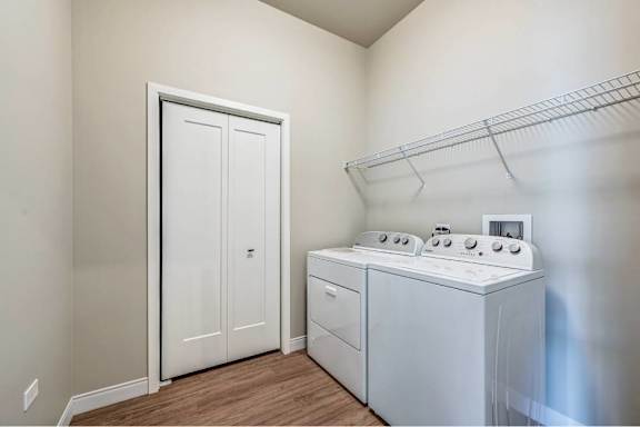 A white door is in a room with a stove and a shelf.
