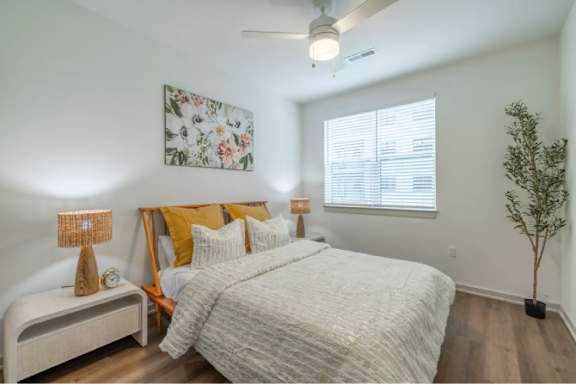 A bedroom with a large bed and a ceiling fan.