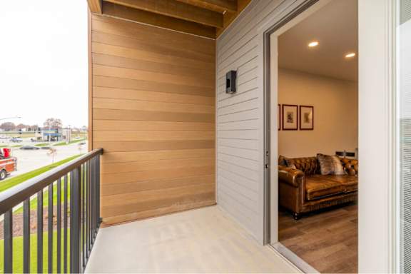 A balcony with a couch and pillows inside.