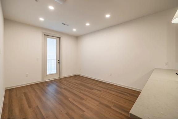 A room with wooden flooring and a white door.
