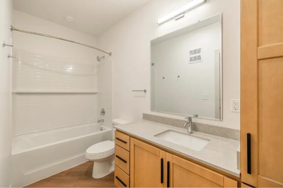 A white bathroom with a toilet, sink, and bathtub.