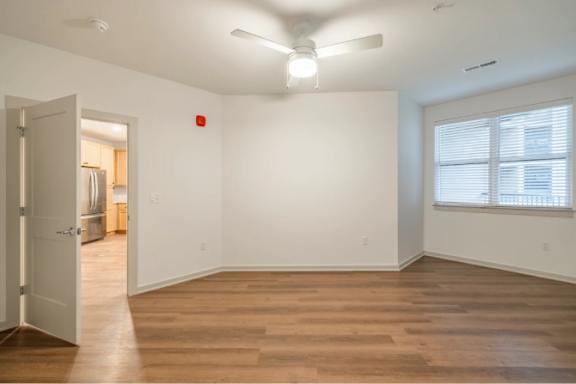 A room with wooden floors and a ceiling fan.