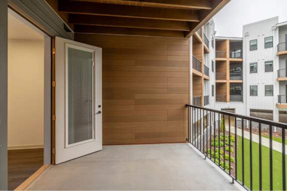 A balcony with a white door and a black railing.