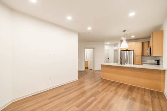 A kitchen with wooden floors and white walls.