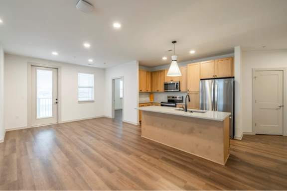 A kitchen with wooden floors and a central island.