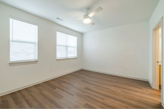A room with wooden floors and a ceiling fan.