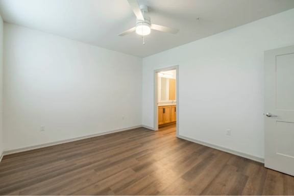 A room with wooden floors and a white ceiling with a light fixture.