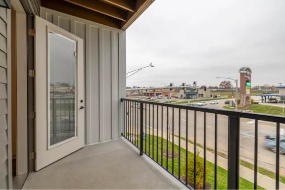 A balcony with a view of a town and a clock tower.