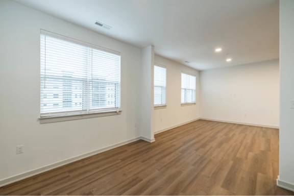 A room with wooden floors and two windows.