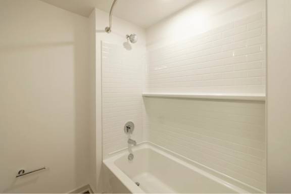 A white bathroom with a tub and shower.