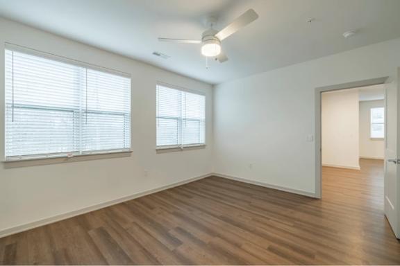 A room with wooden floors and a ceiling fan.