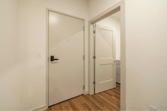A white door with a black handle is open.
