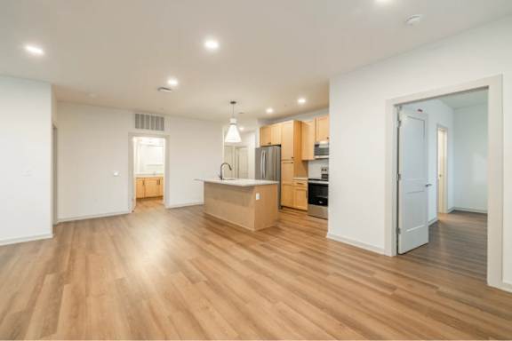 A kitchen with wooden floors and white walls.