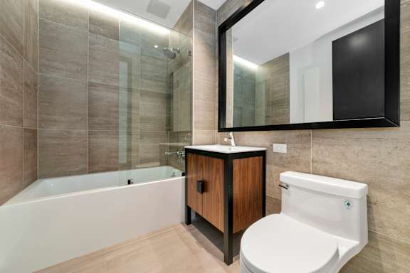 Modern bathroom with soaking tub and glass shower at 1134 Fulton Street Apartments, Brooklyn, NY