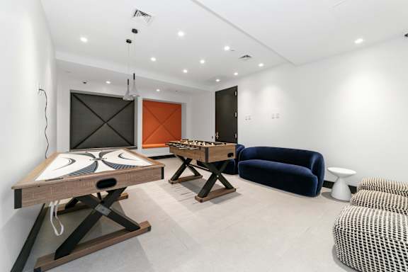Game room with foosball tables and lounge seating at 1134 Fulton Street Apartments, Brooklyn