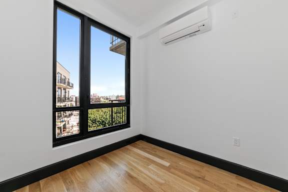 Empty bedroom with hardwood floors and air conditioning at 1134 Fulton Street Apartments, Brooklyn, NY