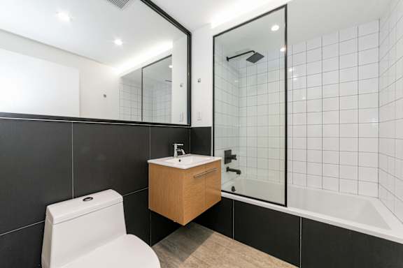 A white toilet sits next to a sink in a modern bathroom.