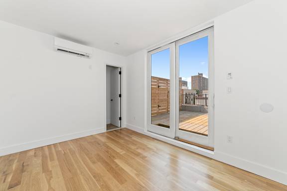 A room with a sliding glass door leading to a balcony.