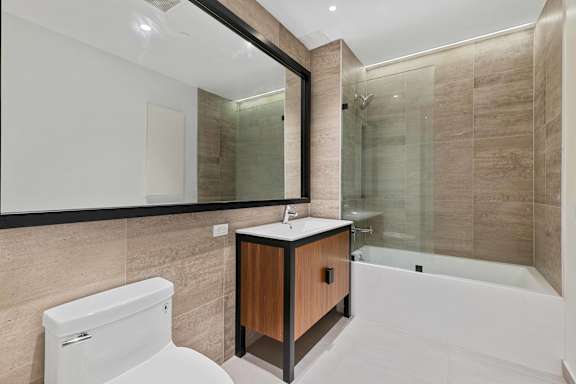 Modern bathroom with wood vanity and soaking tub at 1134 Fulton Street Apartments, Brooklyn, New York