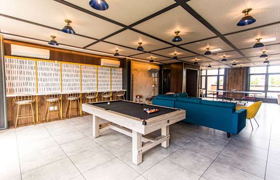 A room with a pool table and a sofa.
