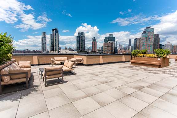 A rooftop patio with a view of the city skyline.