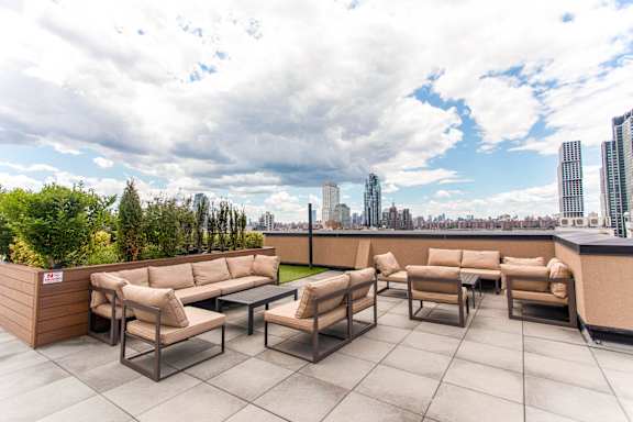 A rooftop patio with a view of the city skyline.