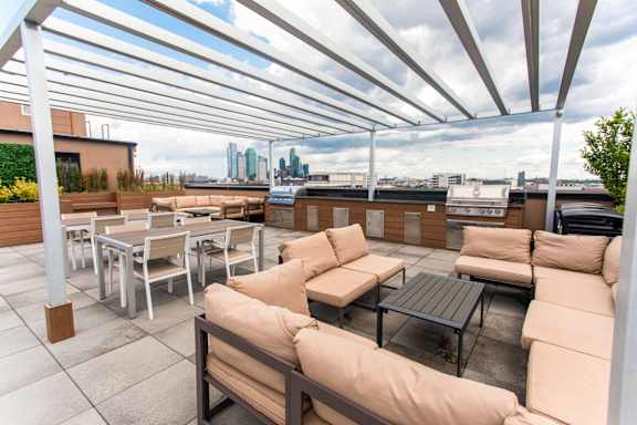 A patio with white furniture and a view of the city.