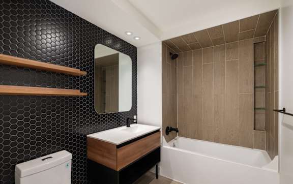 a bathroom with a sink and a tub and a mirror