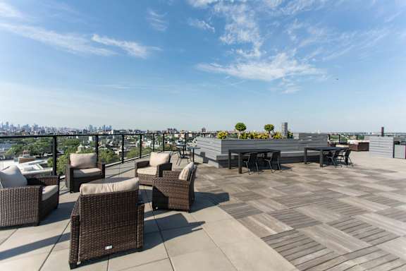 Rooftop terrace with dining areas and skyline views at 1134 Fulton Street Apartments, New York, 11216