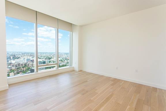 A large empty room with a view of the city.