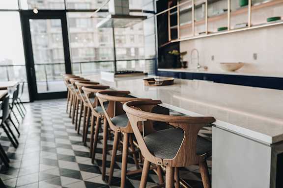 a row of wooden chairs in a restaurant bar at The Lively, Jersey City