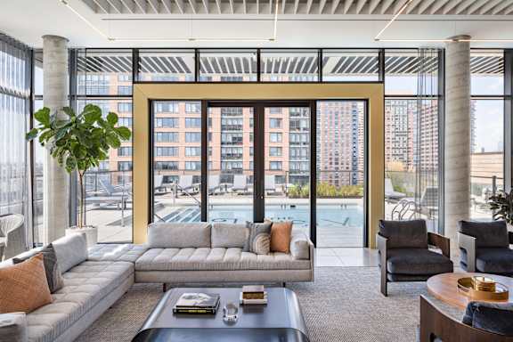a living room with a couch and a table and a swimming pool at The Lively, Jersey City, NJ