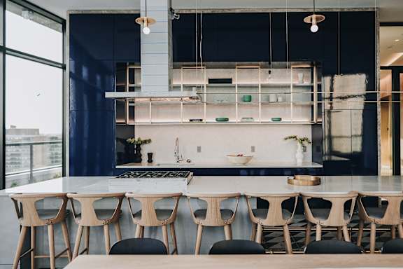 a kitchen with a long table and chairs in front of a large window at The Lively, Jersey City New Jersey