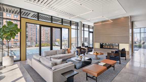 a living room with couches and tables and a fireplace at The Lively, Jersey City, NJ 07302